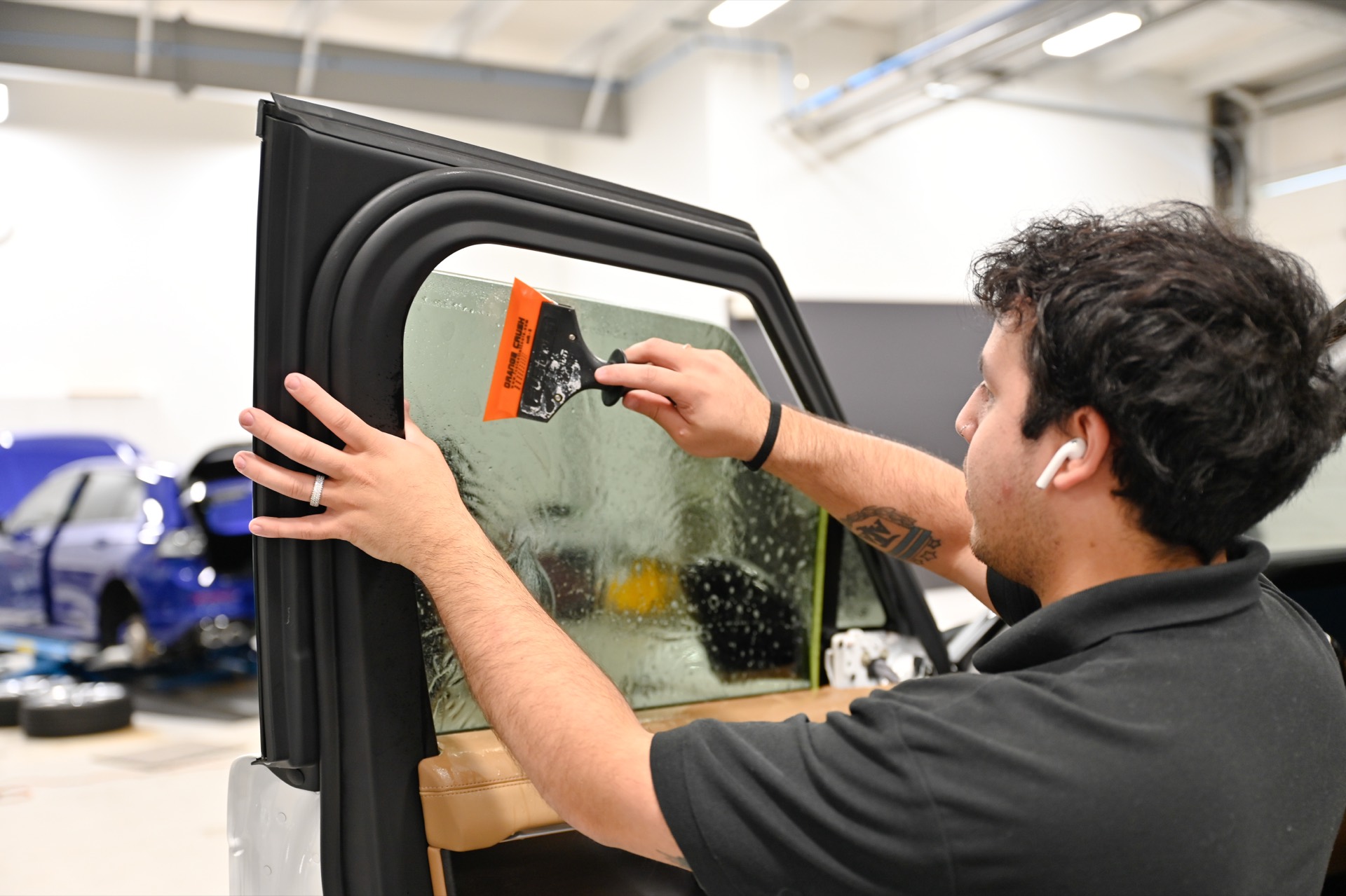 Squeegee finishing the window tint installation